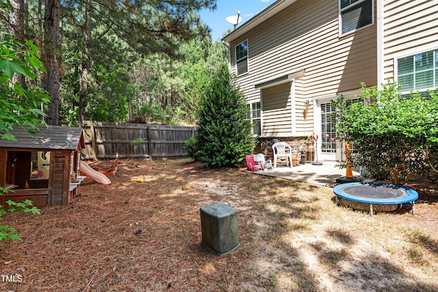 513 Commons Dr, Holly Springs, NC 27540 - view of yard featuring a playground, a trampoline, a patio area, and fence