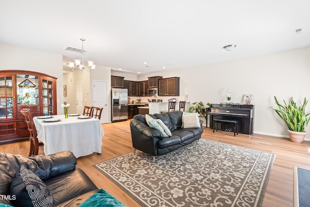 513 Commons Dr, Holly Springs, NC 27540 - living area with visible vents, recessed lighting, light wood-style flooring, and a notable chandelier