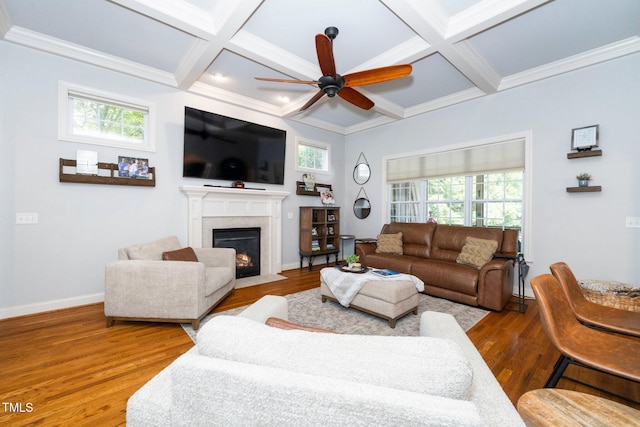 living area featuring a ceiling fan, coffered ceiling, a fireplace with flush hearth, healthy amount of natural light, and wood finished floors