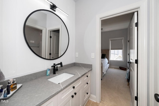 ensuite bathroom featuring vanity and baseboards