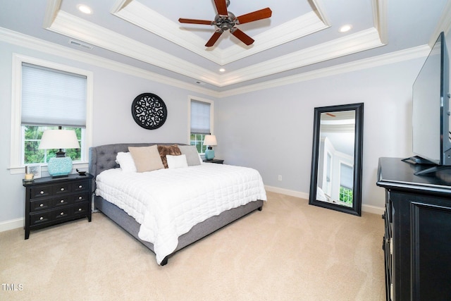 bedroom featuring light colored carpet, a tray ceiling, crown molding, ceiling fan, and baseboards