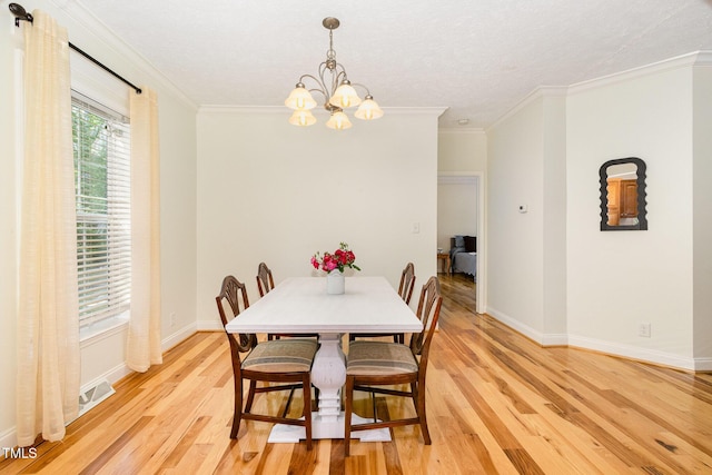 dining area featuring a chandelier, crown molding, baseboards, and light wood-type flooring