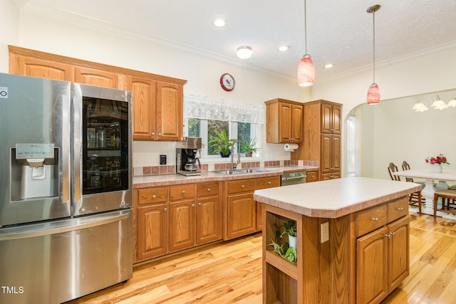 kitchen featuring light countertops, a center island, ornamental molding, arched walkways, and stainless steel appliances