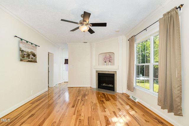 unfurnished living room with ornamental molding, visible vents, light wood finished floors, ceiling fan, and baseboards