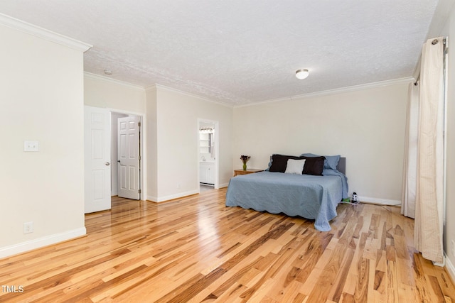 bedroom featuring light wood finished floors, crown molding, a textured ceiling, and baseboards