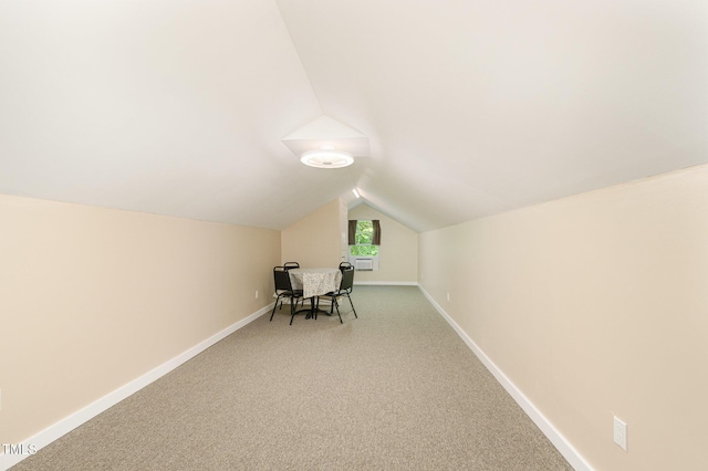 unfurnished office featuring baseboards, carpet floors, and vaulted ceiling