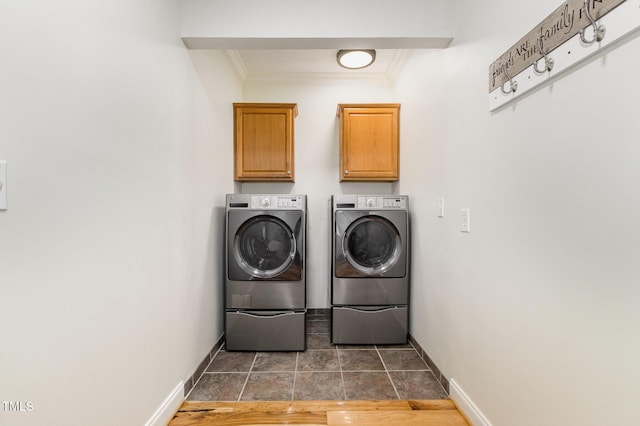 laundry room featuring washer and clothes dryer, crown molding, cabinet space, and baseboards