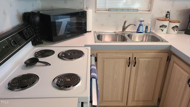 kitchen with light brown cabinetry, white electric range oven, black microwave, a sink, and light countertops