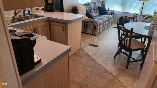 kitchen with visible vents, a sink, and light countertops