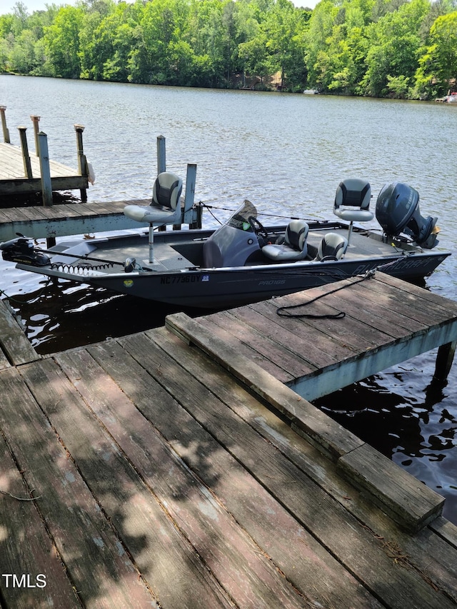 view of dock featuring a water view and a forest view