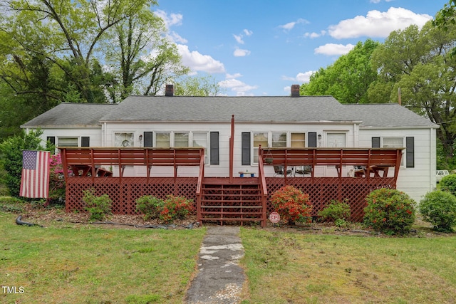 back of property featuring a wooden deck, a yard, and a chimney