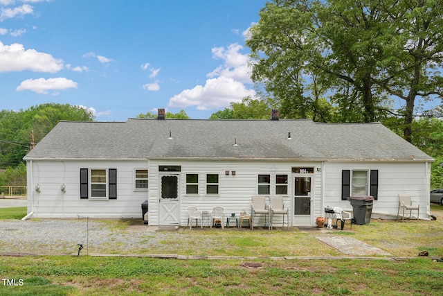 rear view of house with a yard and a chimney