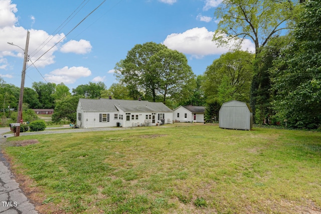 exterior space with a front lawn, an outdoor structure, and a shed