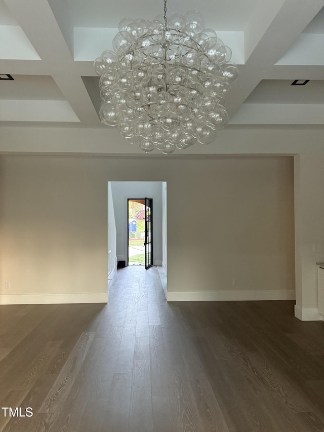 interior space featuring wood finished floors, a chandelier, and baseboards