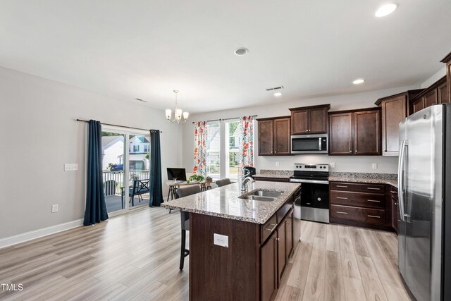 147 Antler Steel Dr, Clayton, NC 27527 - kitchen featuring a breakfast bar, a sink, light wood-style flooring, appliances with stainless steel finishes, and a notable chandelier