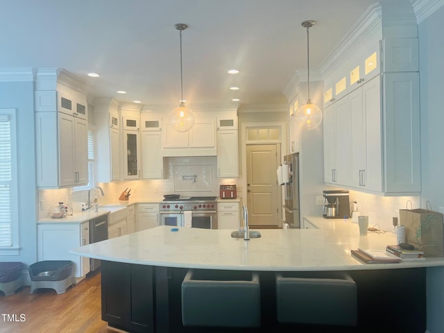 8729 Valentine Ct, Raleigh, NC 27613 - kitchen with stainless steel appliances, a peninsula, a sink, white cabinets, and crown molding
