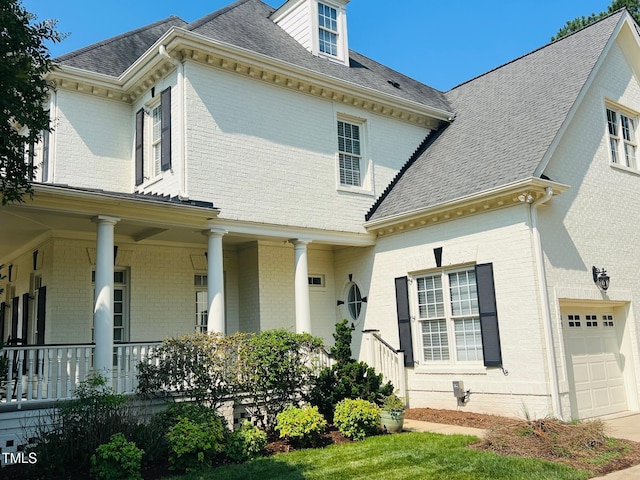 8729 Valentine Ct, Raleigh, NC 27613 - view of front of property with brick siding, an attached garage, a porch, and a shingled roof