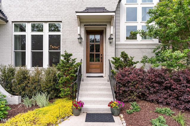 view of exterior entry featuring brick siding