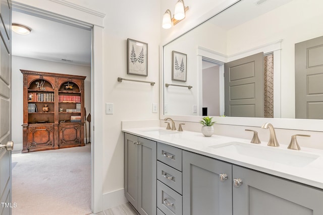 bathroom with double vanity, a sink, and baseboards