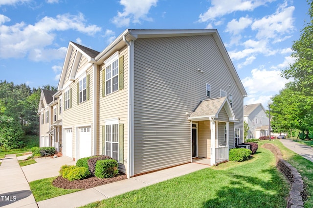 view of front facade featuring an attached garage, a front yard, and concrete driveway