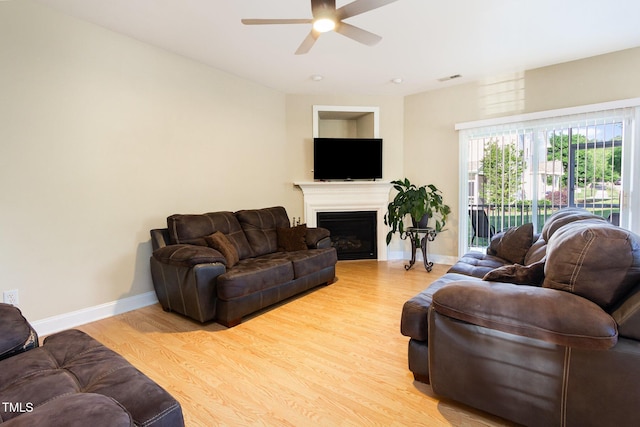 living area with baseboards, ceiling fan, wood finished floors, and visible vents