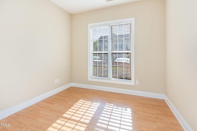 unfurnished room featuring baseboards and wood finished floors