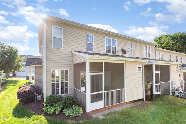 back of property featuring a sunroom and a yard