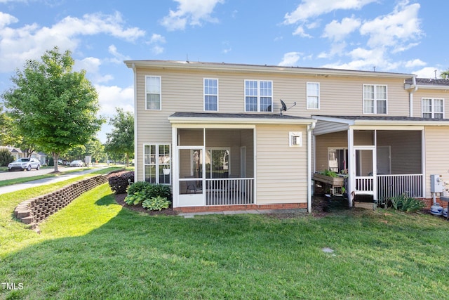 back of property with a yard and a sunroom