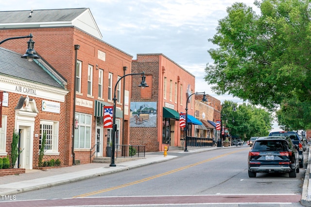 view of road with street lighting, sidewalks, and curbs