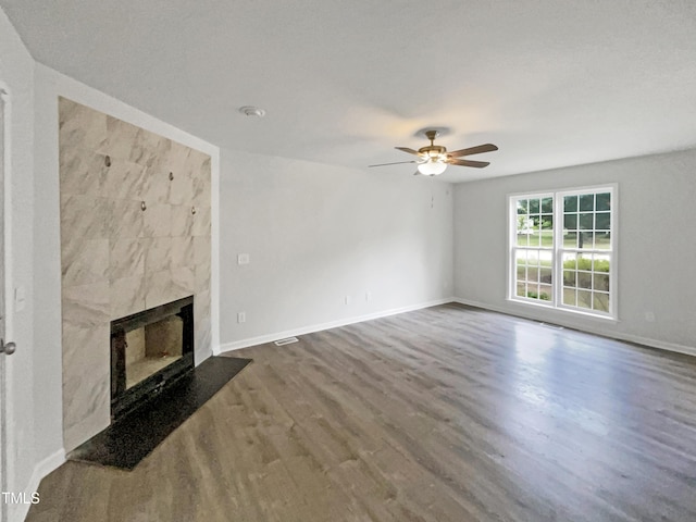 517 Hidden Cellars Dr, Holly Springs, NC 27540 - unfurnished living room featuring a premium fireplace, a ceiling fan, baseboards, wood finished floors, and visible vents