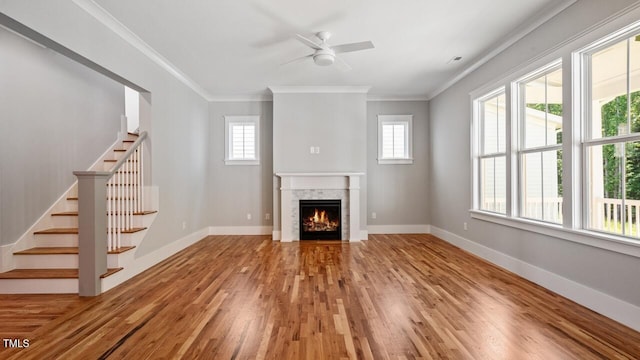 1733 Birdhaven Ln Lot 2217, Wendell, NC 27591 - unfurnished living room featuring ceiling fan, wood finished floors, a warm lit fireplace, stairs, and ornamental molding