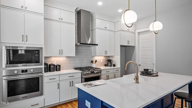 1733 Birdhaven Ln Lot 2217, Wendell, NC 27591 - kitchen with stainless steel appliances, wall chimney range hood, a kitchen breakfast bar, decorative backsplash, and white cabinetry