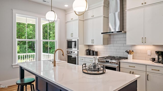 1733 Birdhaven Ln Lot 2217, Wendell, NC 27591 - kitchen with wall chimney range hood, stainless steel appliances, decorative backsplash, an island with sink, and recessed lighting