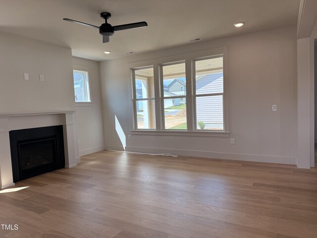 1720 Bright Lantern Way, Wendell, NC 27591 - unfurnished living room featuring light wood finished floors, a ceiling fan, a fireplace, and recessed lighting