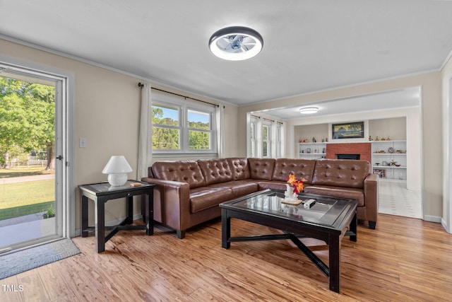 living room featuring ornamental molding, a wealth of natural light, and light wood-style floors