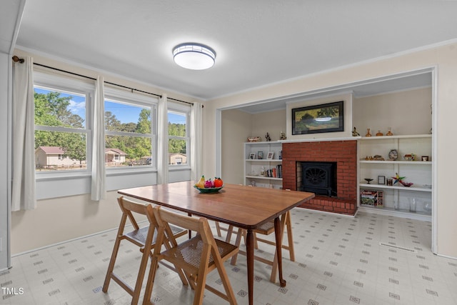 dining area featuring light floors and a fireplace
