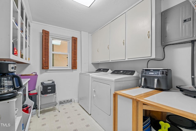clothes washing area with electric panel, light floors, cabinet space, and washer and dryer