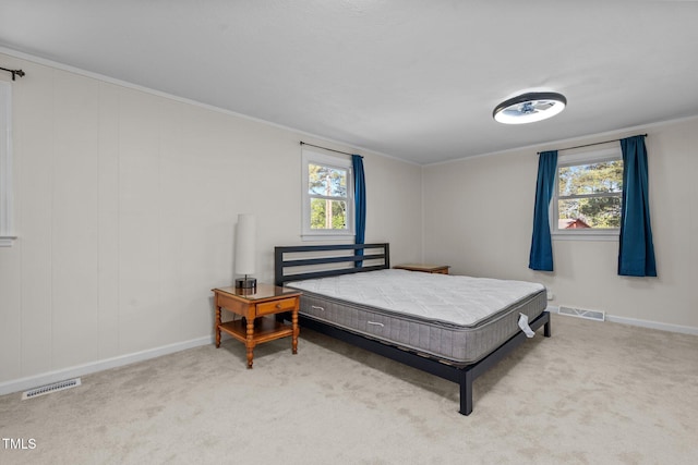 bedroom with carpet flooring, visible vents, and multiple windows