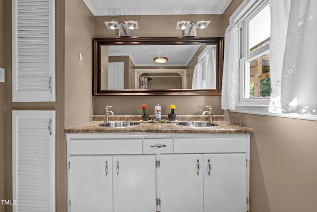 full bath featuring double vanity, crown molding, and a sink
