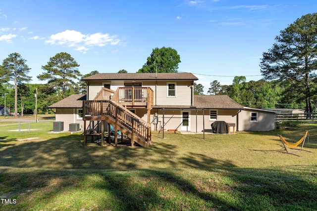back of property with a lawn, stairs, a wooden deck, and central air condition unit