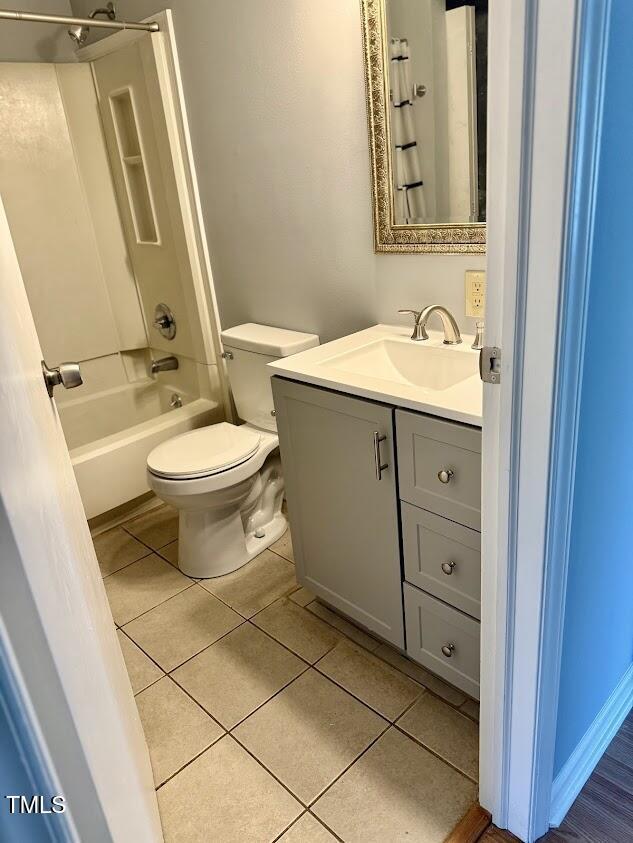 bathroom with tile patterned floors, toilet, vanity, and shower / bathtub combination with curtain