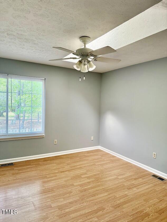 unfurnished room with light wood-style floors, baseboards, and ceiling fan