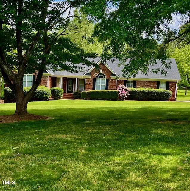 ranch-style house featuring brick siding and a front yard