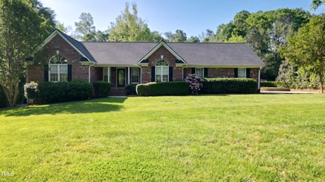 ranch-style house featuring a front lawn and brick siding