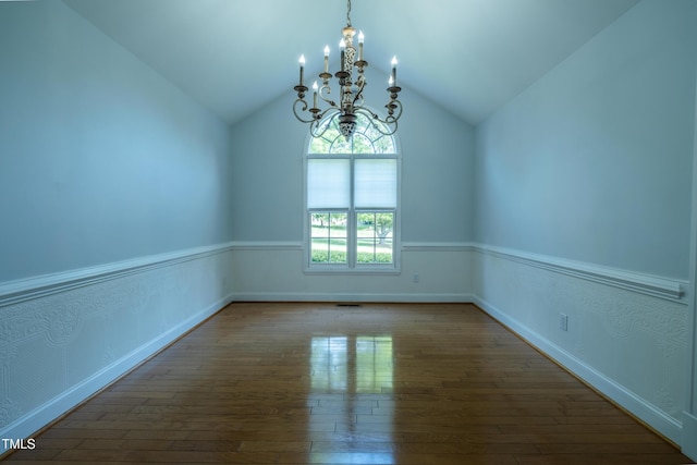 spare room with baseboards, lofted ceiling, a chandelier, and hardwood / wood-style flooring