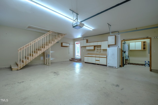 garage with freestanding refrigerator, a garage door opener, and gas water heater