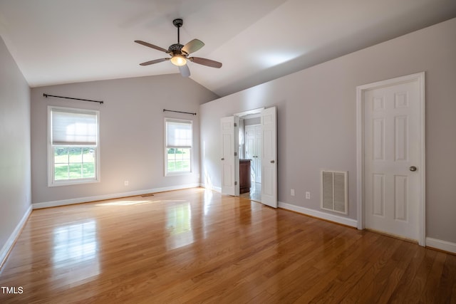 interior space featuring baseboards, lofted ceiling, wood finished floors, and visible vents