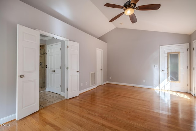 unfurnished bedroom with ceiling fan, visible vents, baseboards, lofted ceiling, and light wood-style floors