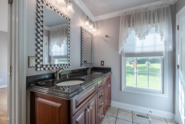 bathroom with double vanity, baseboards, visible vents, and a sink