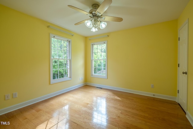 empty room featuring visible vents, light wood-style floors, ceiling fan, and baseboards